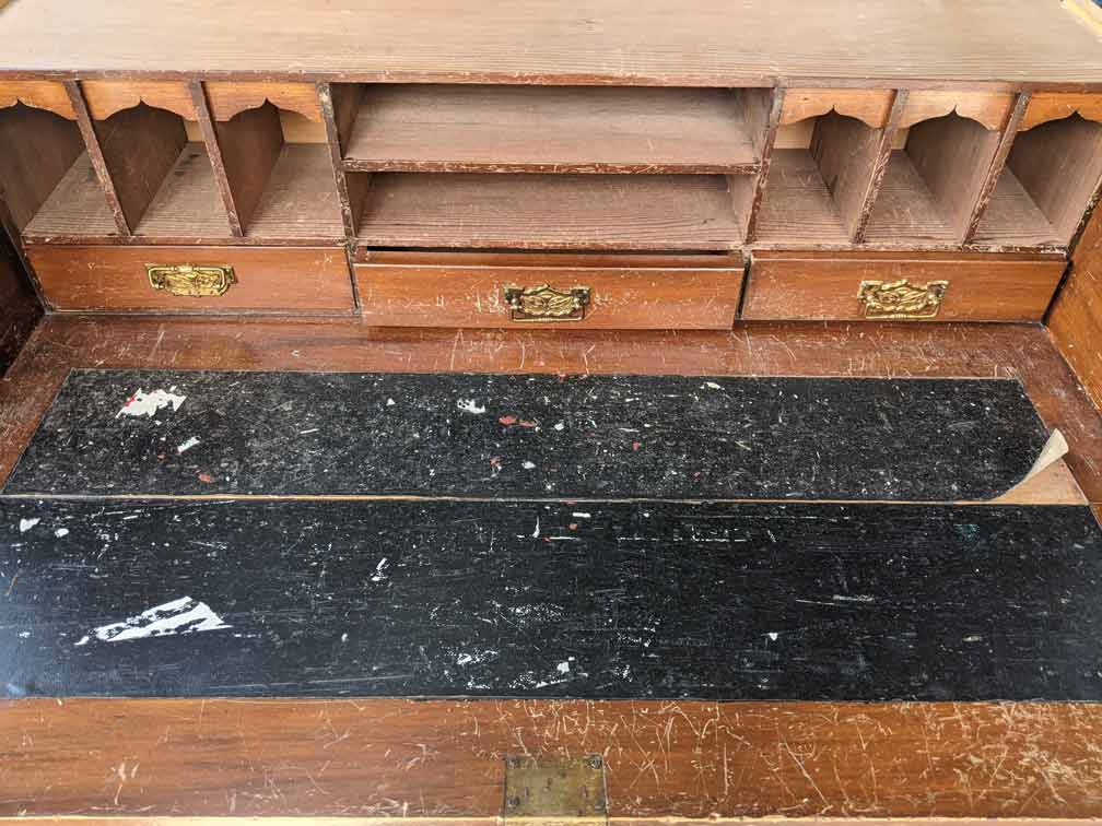 This drawer from an antique writing desk was badly damaged, and required a new leather insert, as well as cleaning, repair, and restoration work.